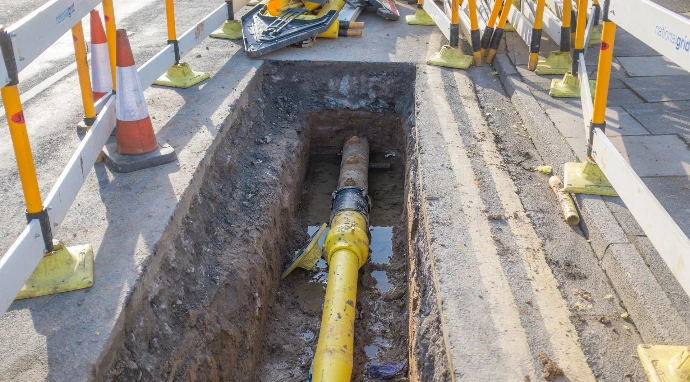 An inspection pit with yellow polyethylene gas pipe laid